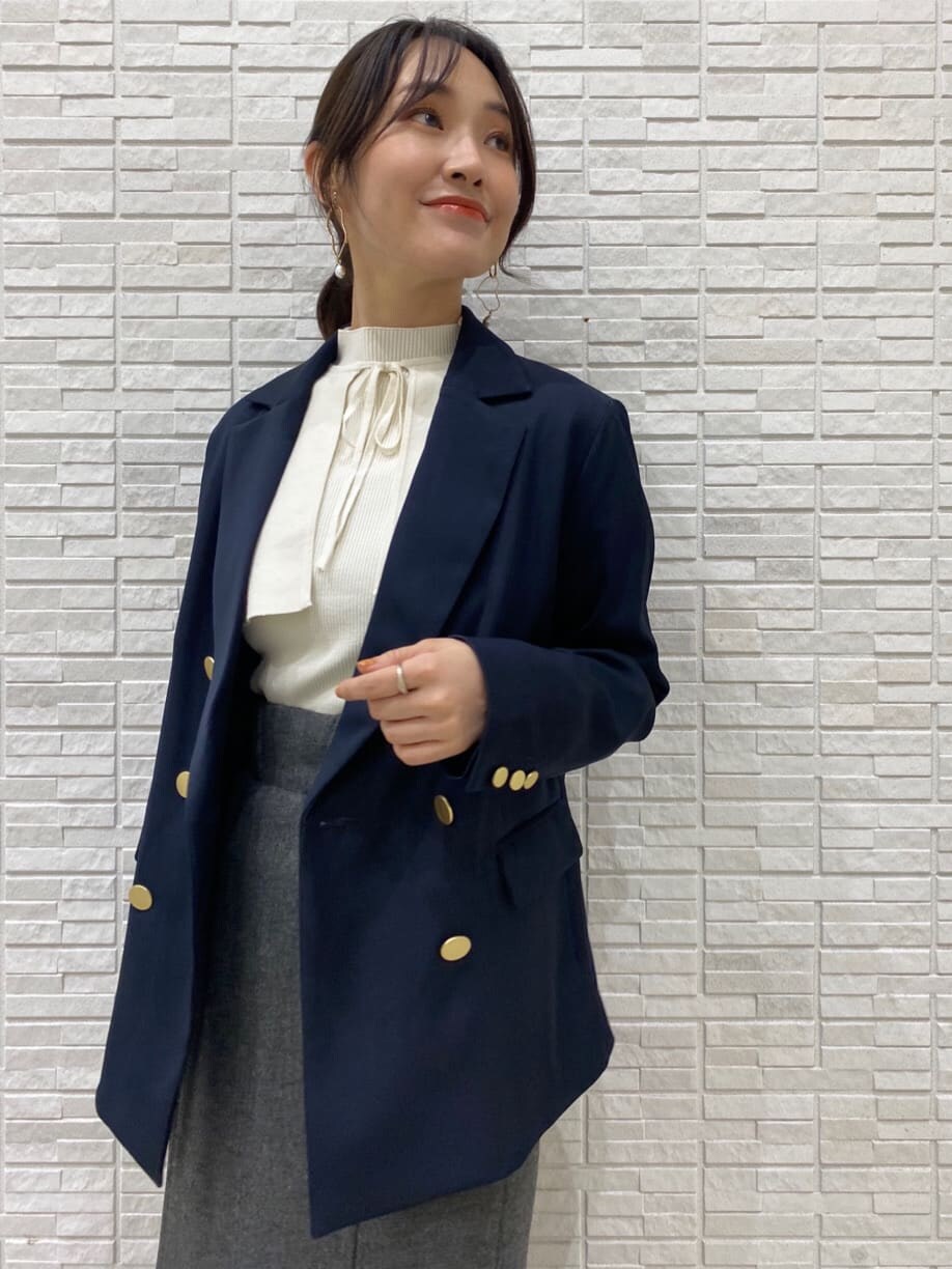 ブラック系のブーツ、ブルー系のテーラードジャケット、グレー系のスカートを着用したレディースの秋コーディネートの2枚目の写真