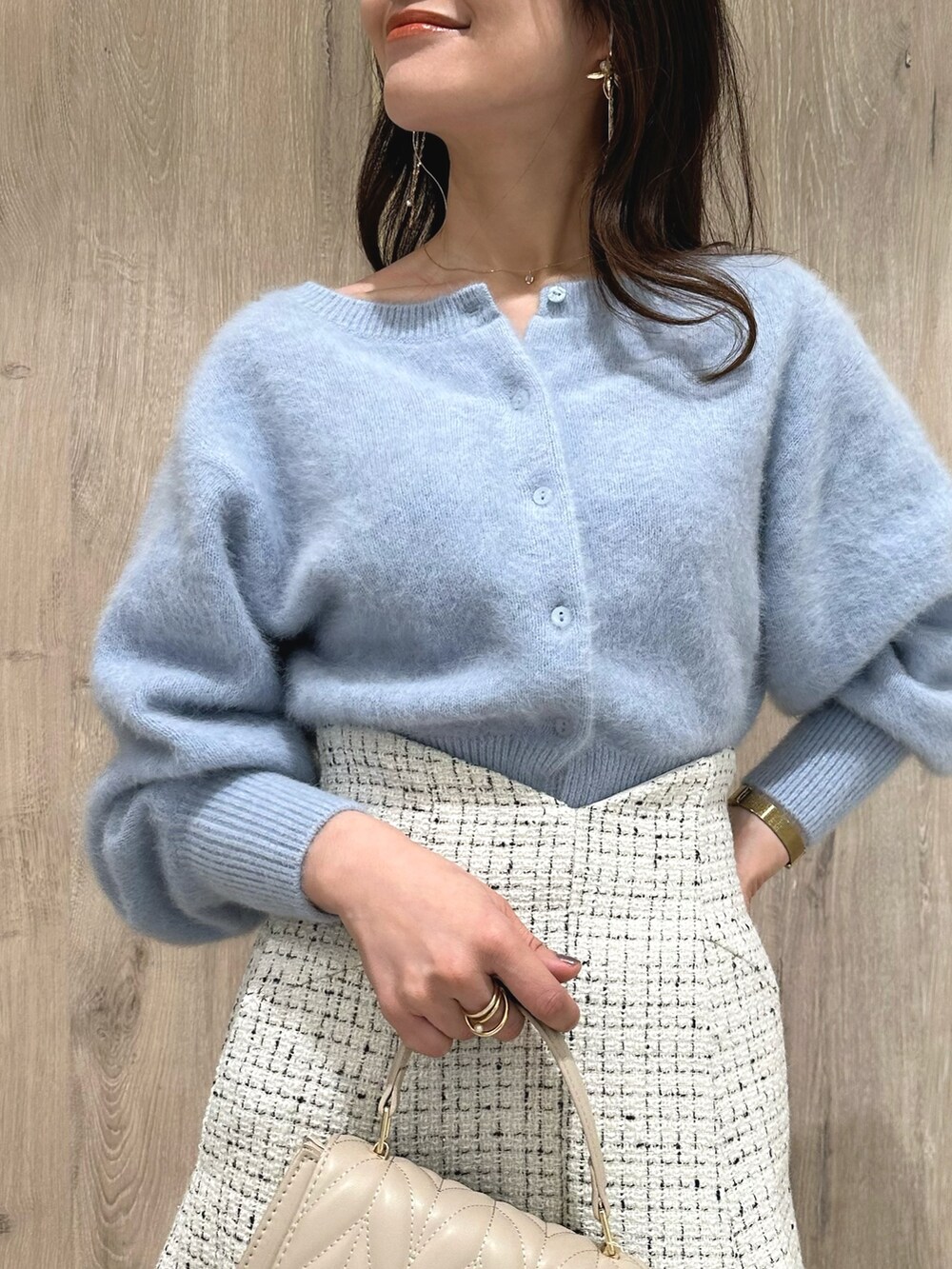 ホワイト系のスカート、ブルー系のカーディガン/ボレロ、ブラウン系のブーツを着用したレディースの秋コーディネートの6枚目の写真