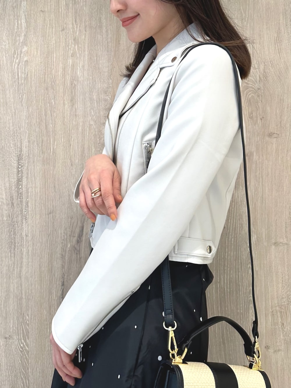 ピンク系のニット/セーター、ブラック系のハンドバッグ、その他のスカートを着用したレディースの春コーディネートの6枚目の写真