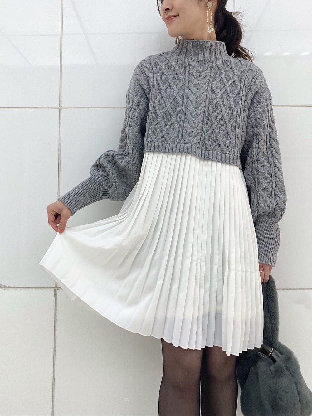 グリーン系のブルゾン、ブラック系のブーツ、グレー系のワンピースを着用したレディースの冬コーディネートの7枚目の写真