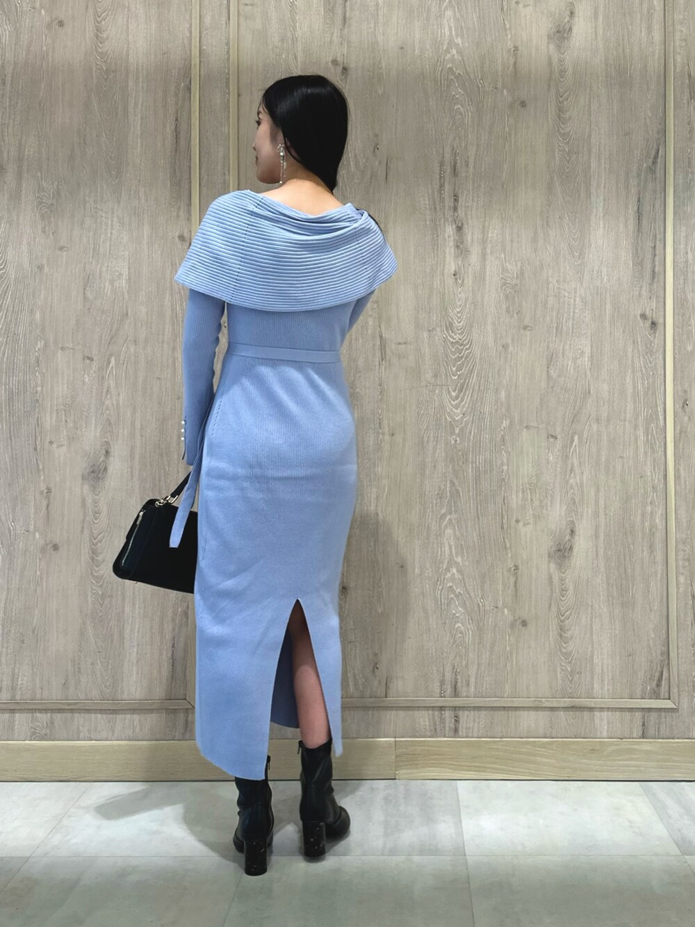 ブラック系のブーツ、ブルー系のワンピース、ブラック系のショルダーバッグを着用したレディースの冬コーディネートの3枚目の写真