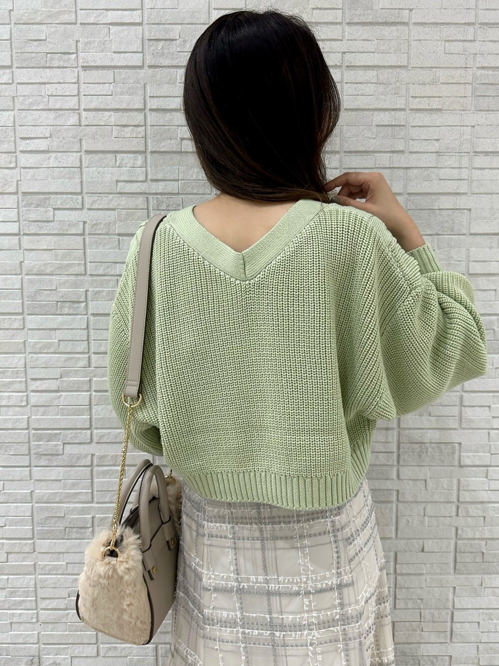 ホワイト系のハンドバッグ、グリーン系のカーディガン/ボレロ、ホワイト系のスカートを着用したレディースの秋コーディネートの8枚目の写真