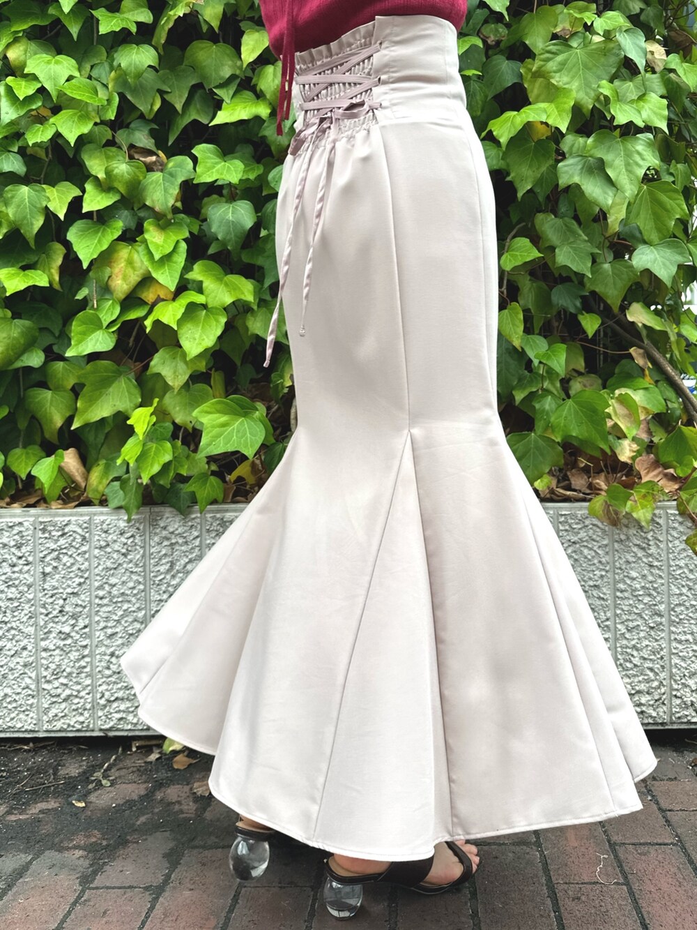 ブラウン系のサンダル、レッド系のニット/セーター、ピンク系のスカートを着用したレディースの夏コーディネートの7枚目の写真