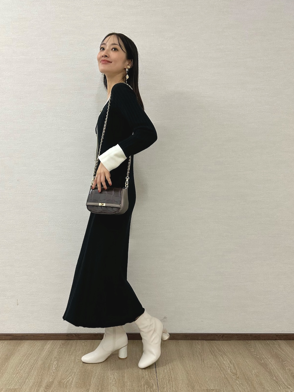 ホワイト系のブーツ、ブラウン系のハンドバッグ、ブラック系のワンピースを着用したレディースの秋コーディネートの2枚目の写真