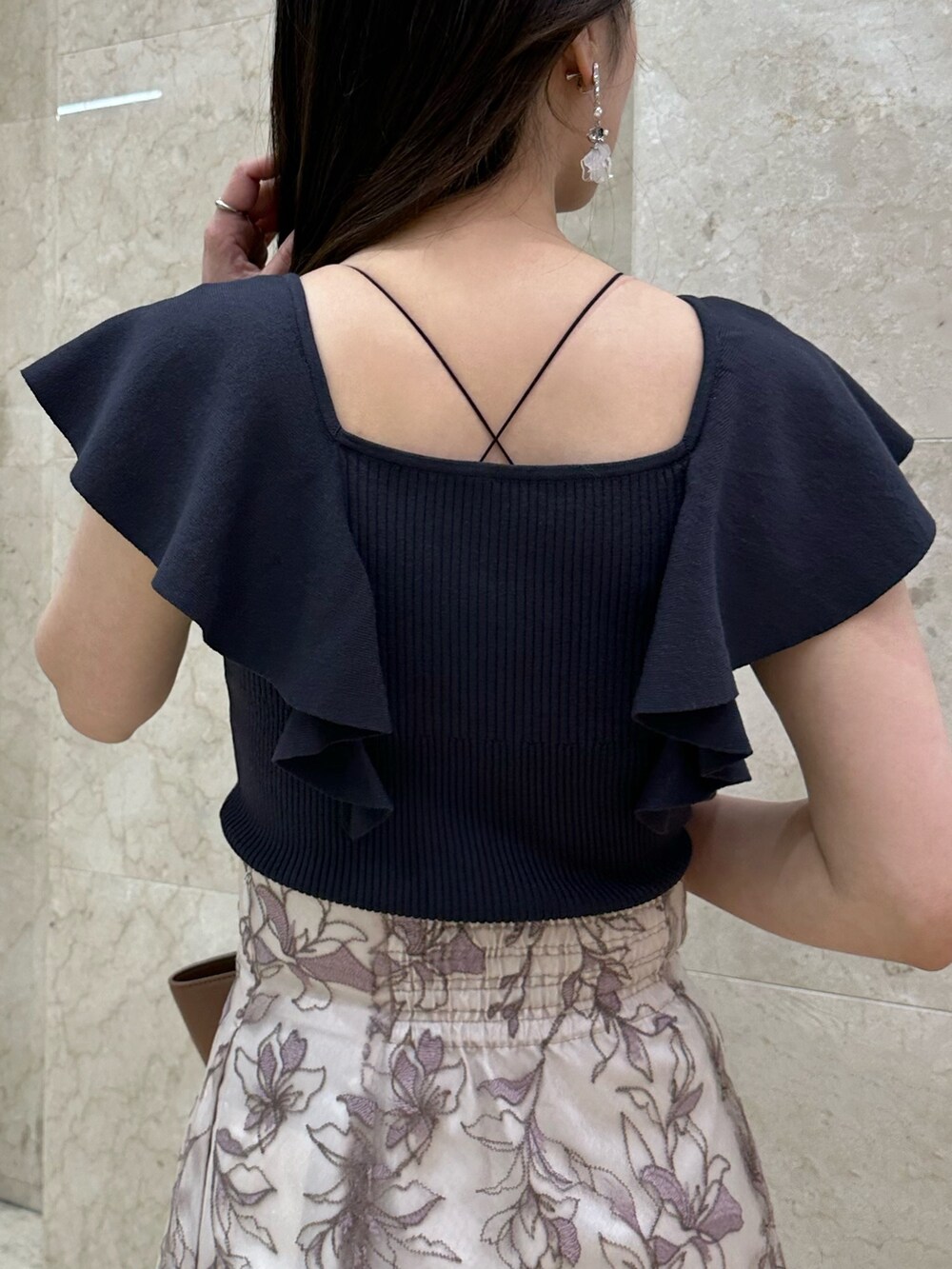 ブラック系のチューブトップ、ブラウン系のサンダル、ピンク系のスカートを着用したレディースの春コーディネートの5枚目の写真