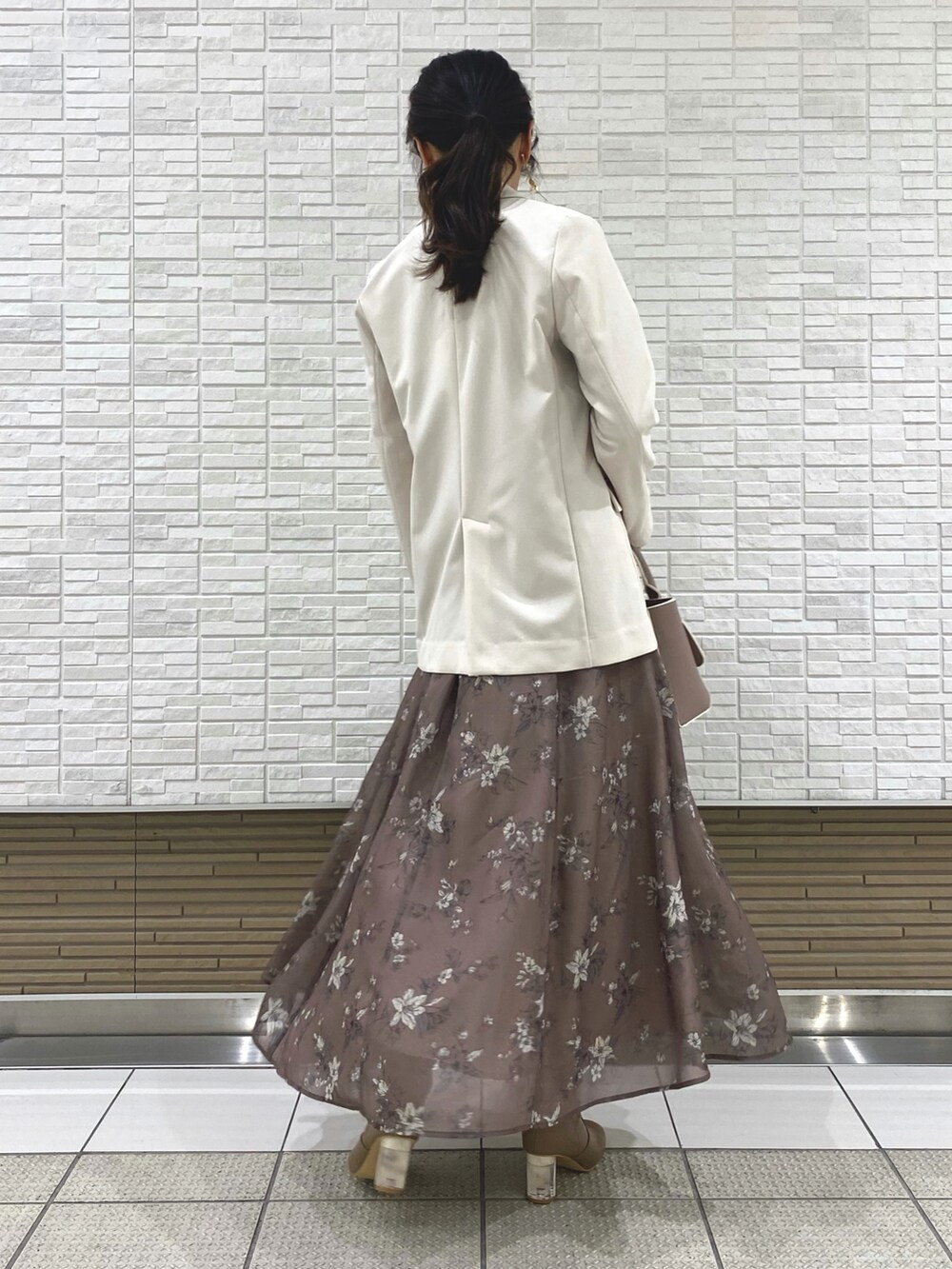 ベージュ系のブーツ、ホワイト系のテーラードジャケット、ベージュ系のハンドバッグを着用したレディースの冬コーディネートの4枚目の写真