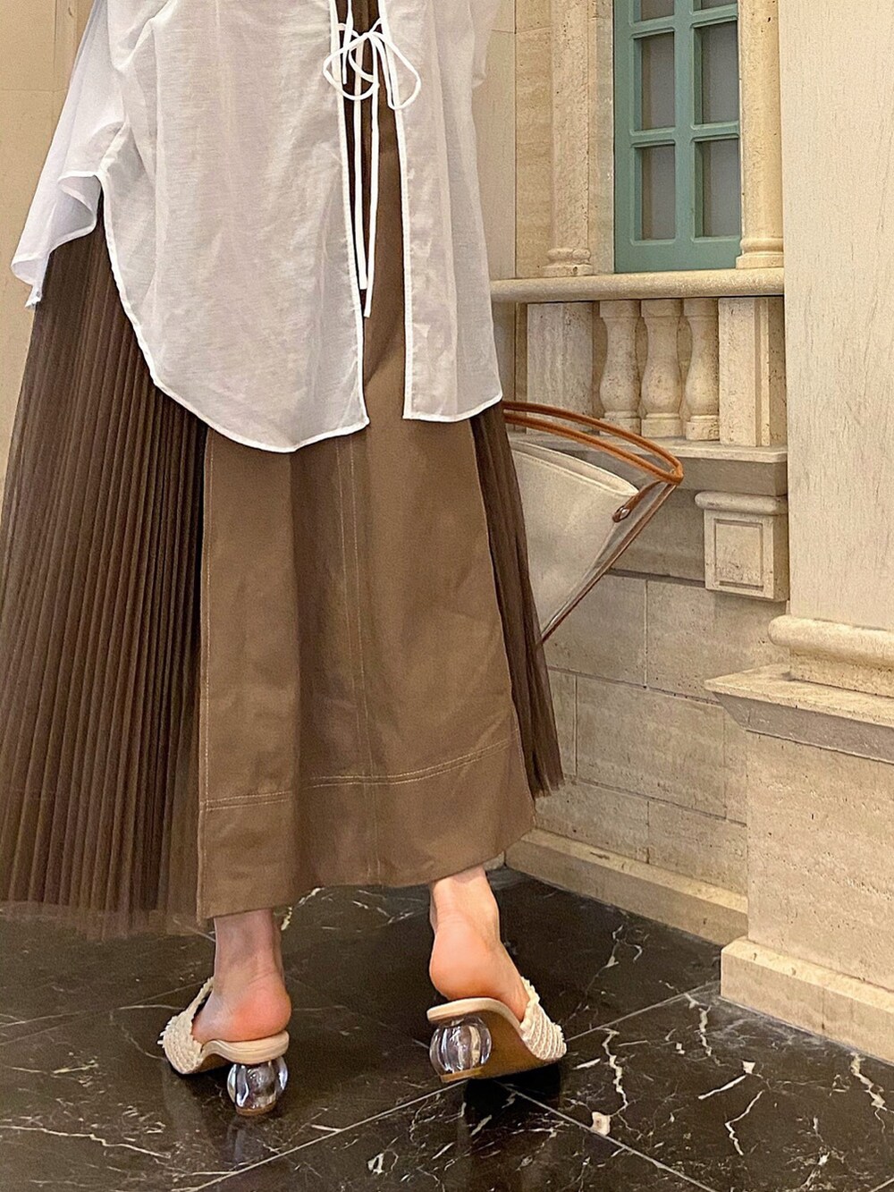 ブラウン系のトートバッグ、ホワイト系のシャツ/ブラウス、ブラウン系のワンピースを着用したレディースの春コーディネートの6枚目の写真