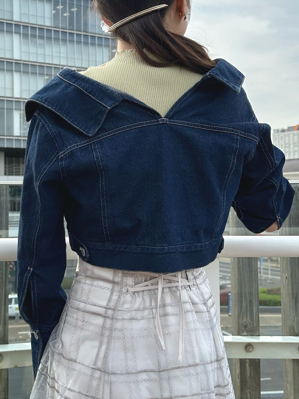 ホワイト系のハンドバッグ、グリーン系のワンピース、ブルー系のデニムジャケットを着用したレディースの春コーディネートの7枚目の写真