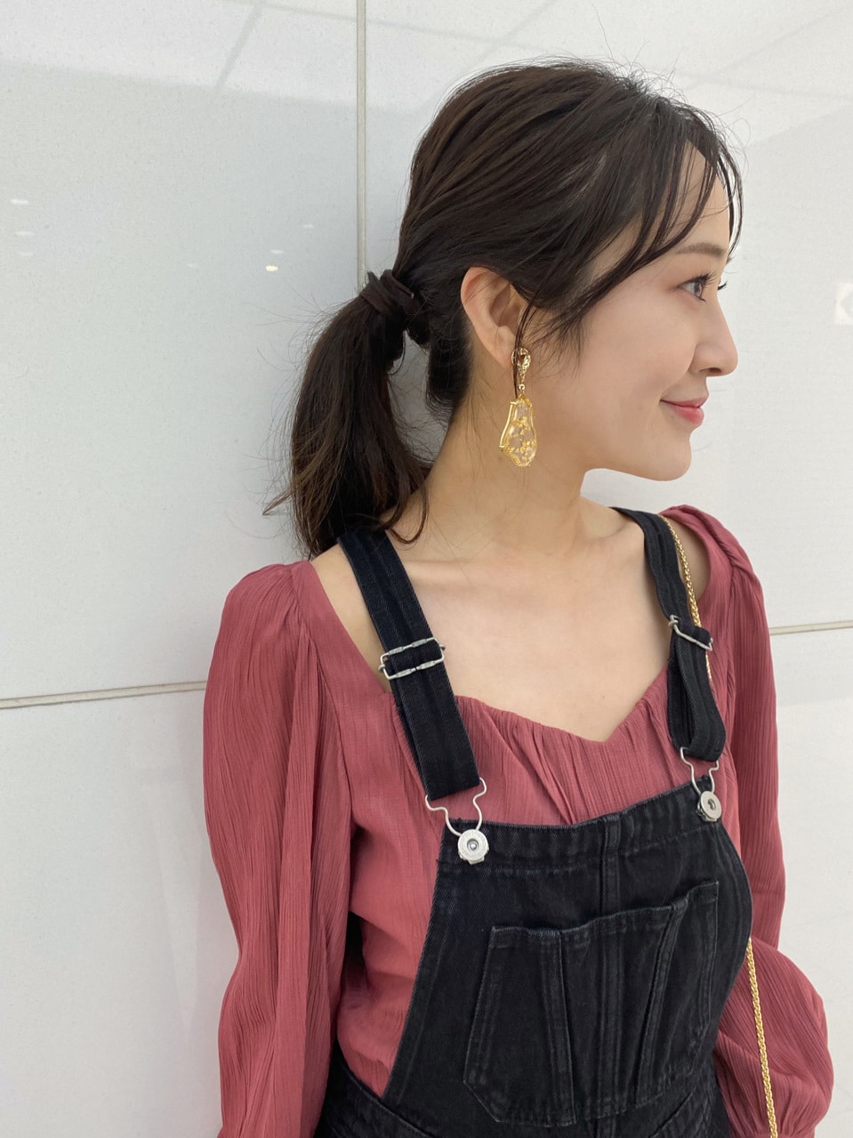 ブラック系のサロペット/オーバーオール、レッド系のシャツ/ブラウス、ベージュ系のサンダルを着用したレディースの春コーディネートの4枚目の写真