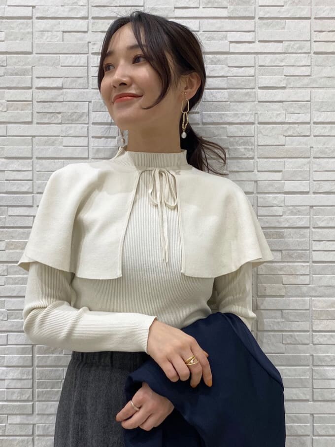 ブラック系のブーツ、ブルー系のテーラードジャケット、グレー系のスカートを着用したレディースの秋コーディネートの8枚目の写真