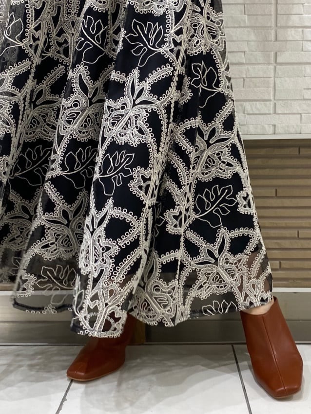 ベージュ系のキャミソール、ブラック系のニット/セーター、ブラック系のスカートを着用したレディースの夏コーディネートの9枚目の写真