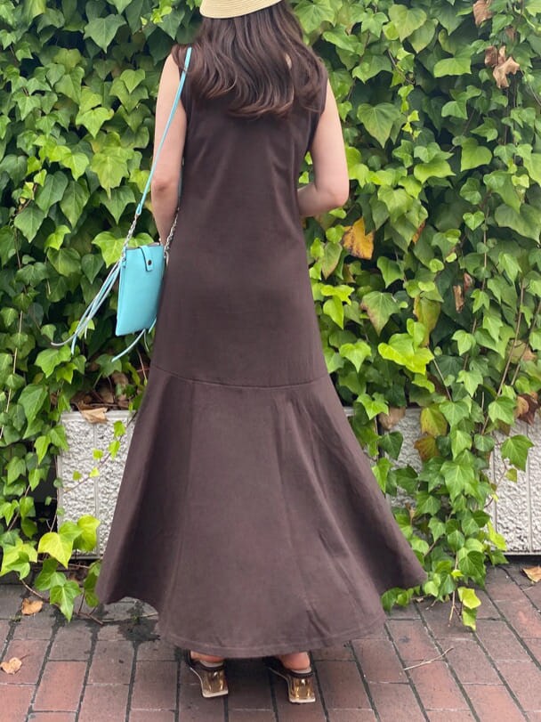 グリーン系のショルダーバッグ、ブラウン系のサンダル、ベージュ系のキャミソールを着用したレディースの夏コーディネートの6枚目の写真