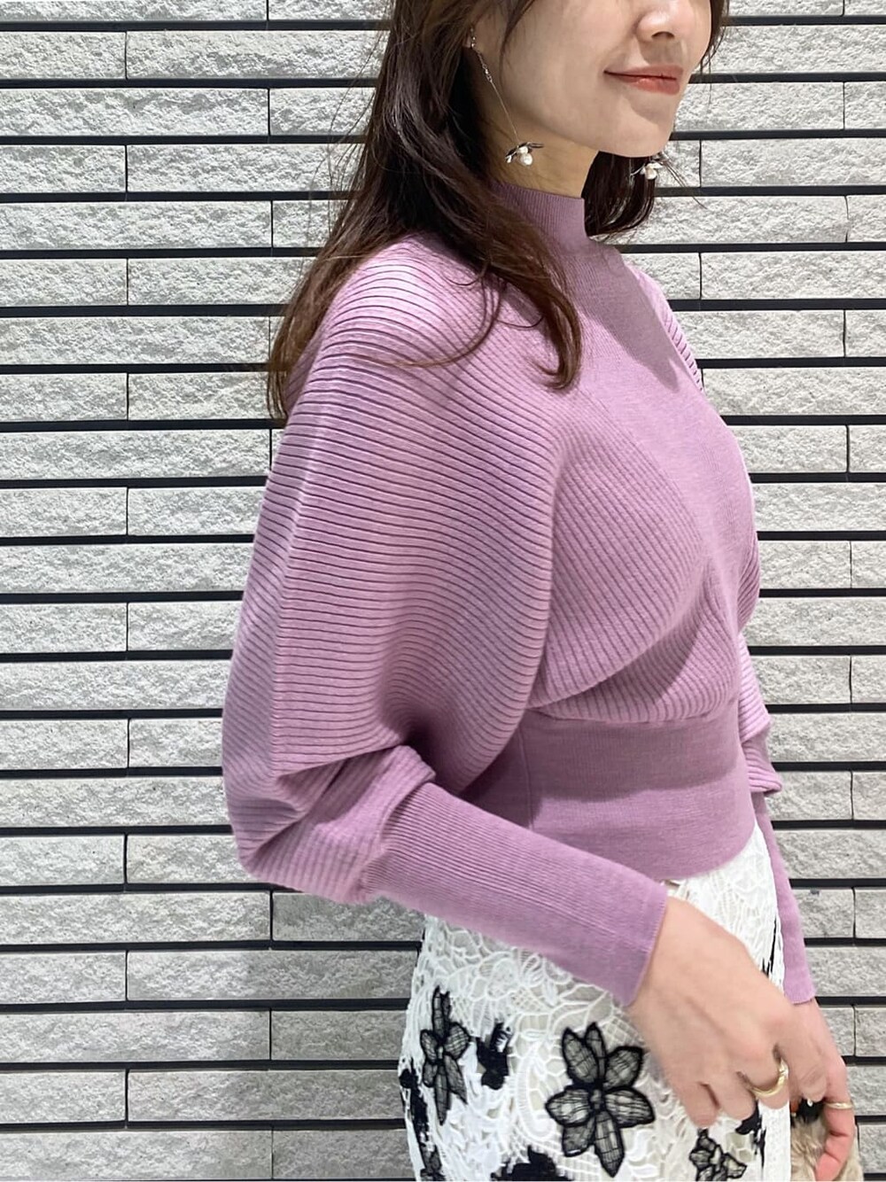 ホワイト系のスカート、ブラック系のブーツ、ピンク系のニット/セーターを着用したレディースの冬コーディネートの4枚目の写真