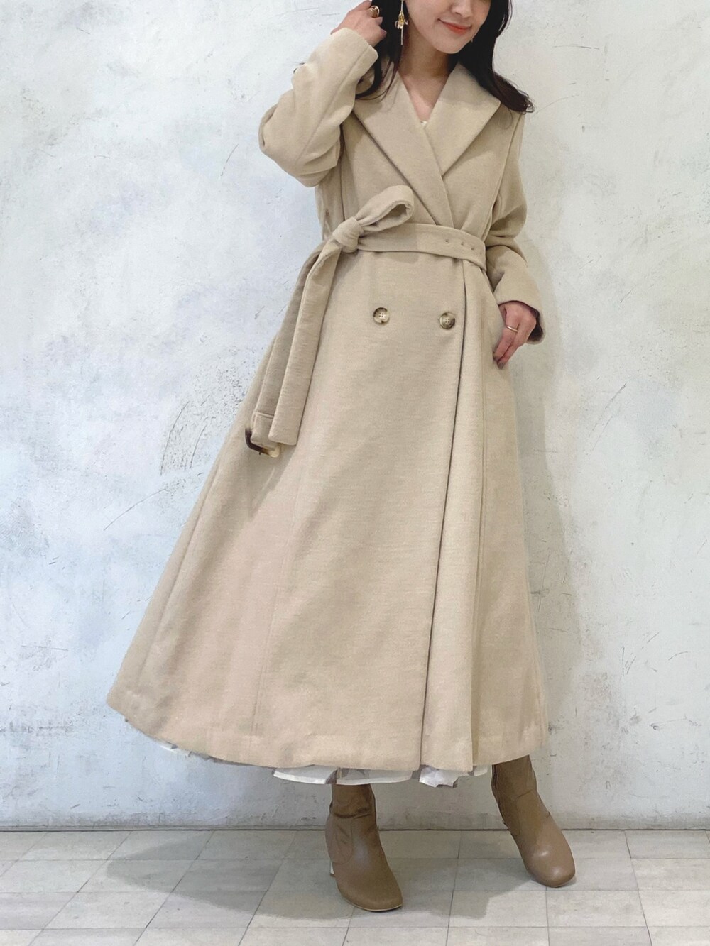ホワイト系のワンピース、ベージュ系のブーツ、ベージュ系のチェスターコートを着用したレディースの冬コーディネートの9枚目の写真