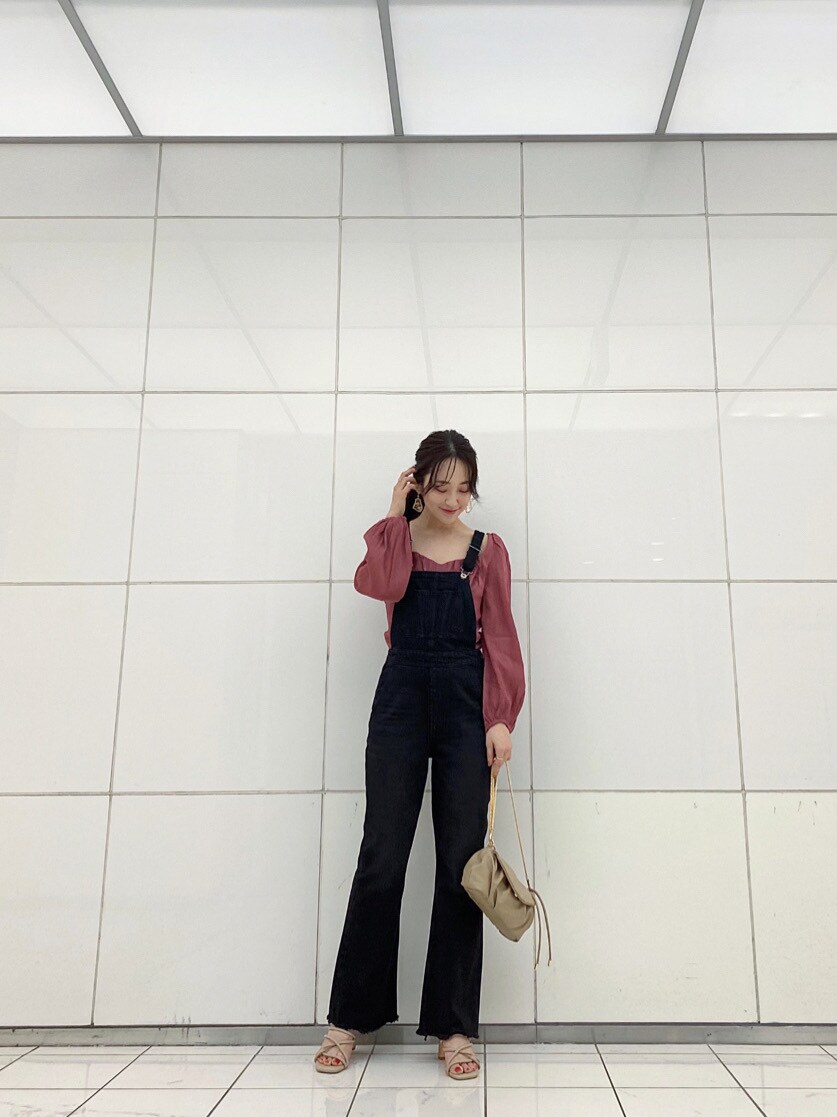 ブラック系のサロペット/オーバーオール、レッド系のシャツ/ブラウス、ベージュ系のサンダルを着用したレディースの春コーディネートの2枚目の写真