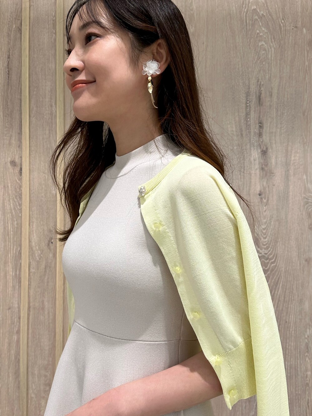 イエロー系のカーディガン/ボレロ、ホワイト系のワンピース、その他のサンダルを着用したレディースの春コーディネートの6枚目の写真