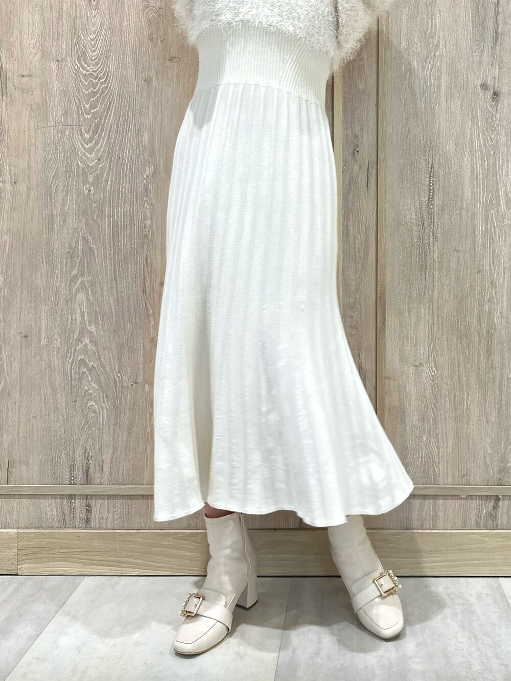 ホワイト系のブーツ、ホワイト系のワンピース、ゴールド系のイヤリングを着用したレディースの春コーディネートの7枚目の写真