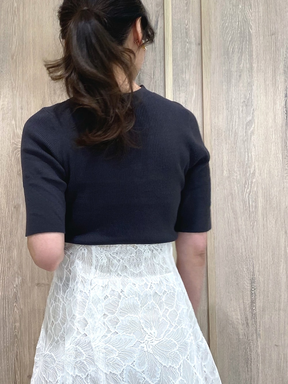 グレー系のスニーカー、ホワイト系のスカート、グレー系のニット/セーターを着用したレディースの冬コーディネートの6枚目の写真