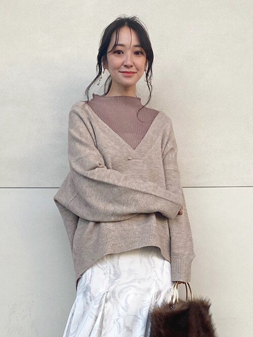 ホワイト系のブーツ、ホワイト系のスカート、ベージュ系のニット/セーターを着用したレディースの冬コーディネートの4枚目の写真