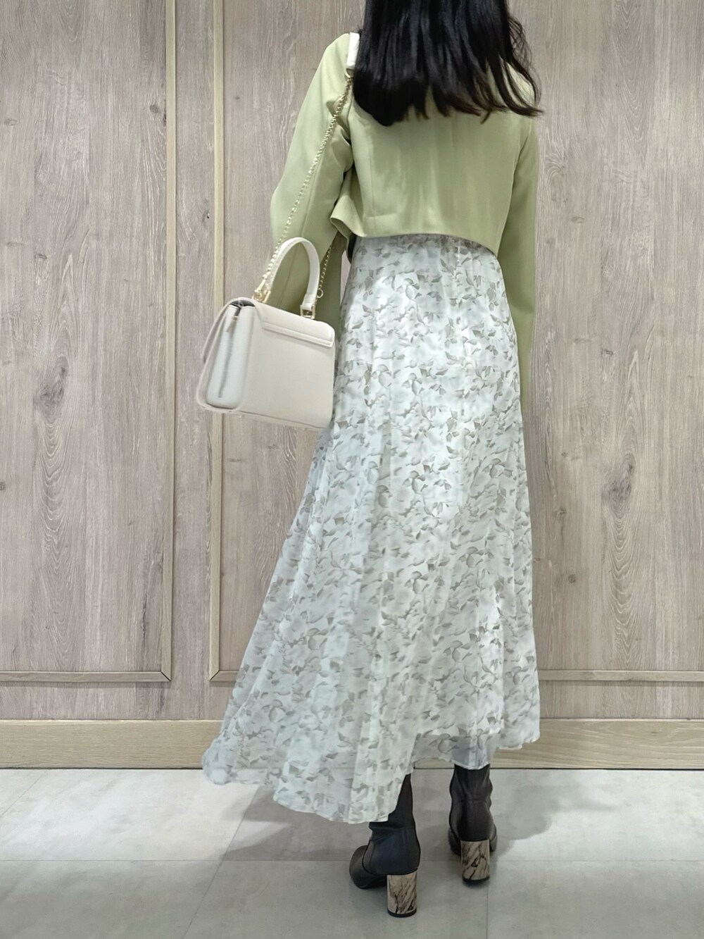 ホワイト系のハンドバッグ、ブラウン系のブーツ、グリーン系のテーラードジャケットを着用したレディースの冬コーディネートの4枚目の写真