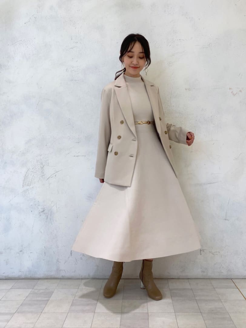 ベージュ系のブーツ、ベージュ系のテーラードジャケット、ホワイト系のワンピースを着用したレディースの秋コーディネートの2枚目の写真