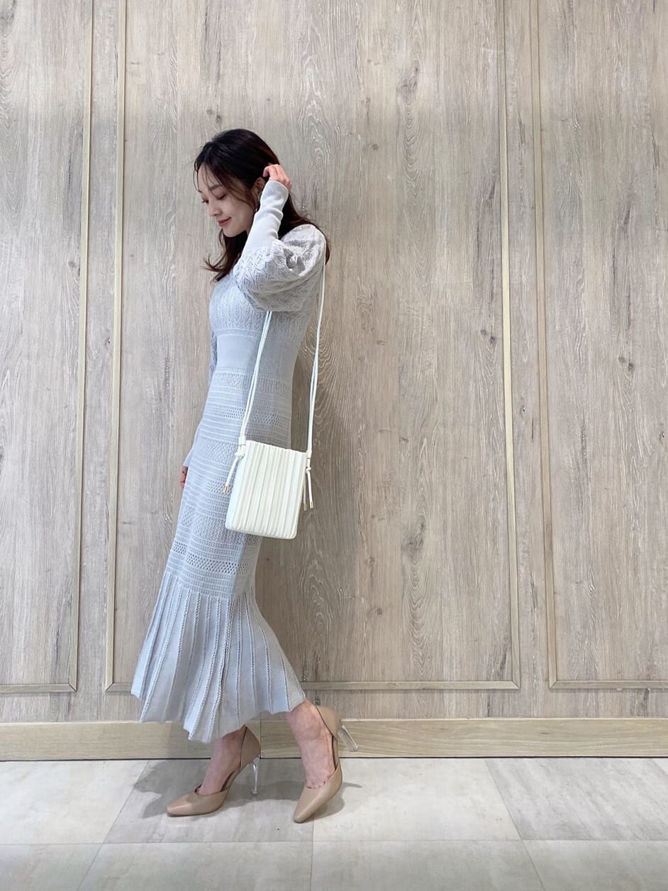 ベージュ系のパンプス、グレー系のワンピース、ホワイト系のハンドバッグを着用したレディースの冬コーディネートの2枚目の写真