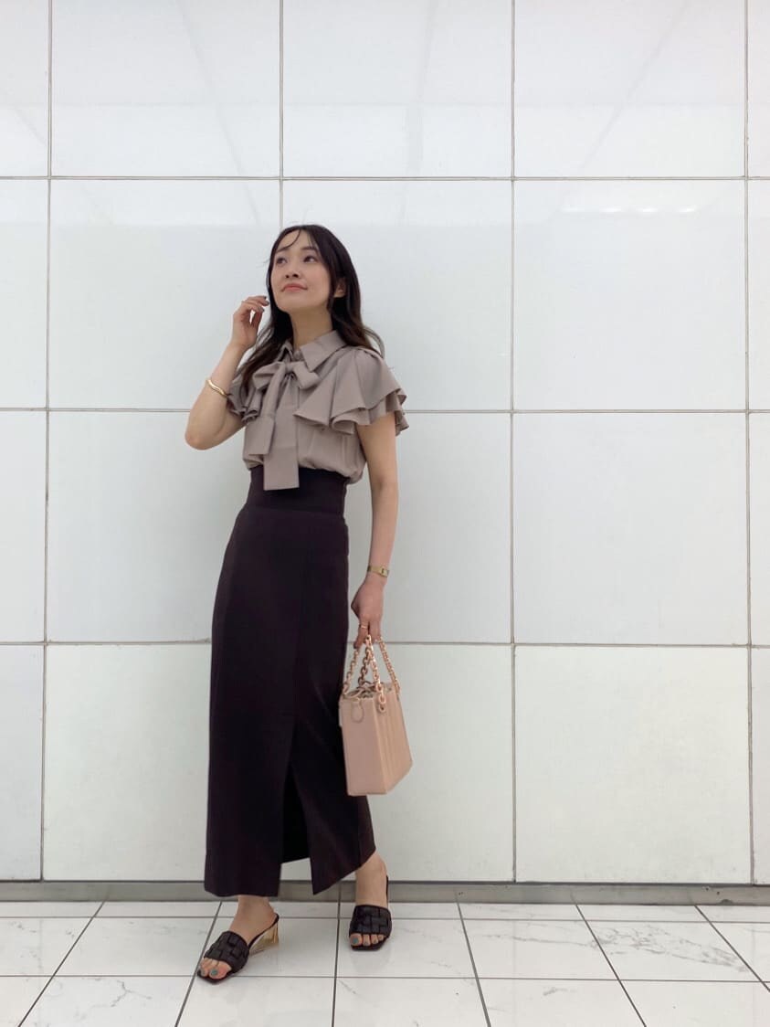 ピンク系のハンドバッグ、ブラウン系のサンダル、ベージュ系のシャツ/ブラウスを着用したレディースの夏コーディネートの2枚目の写真