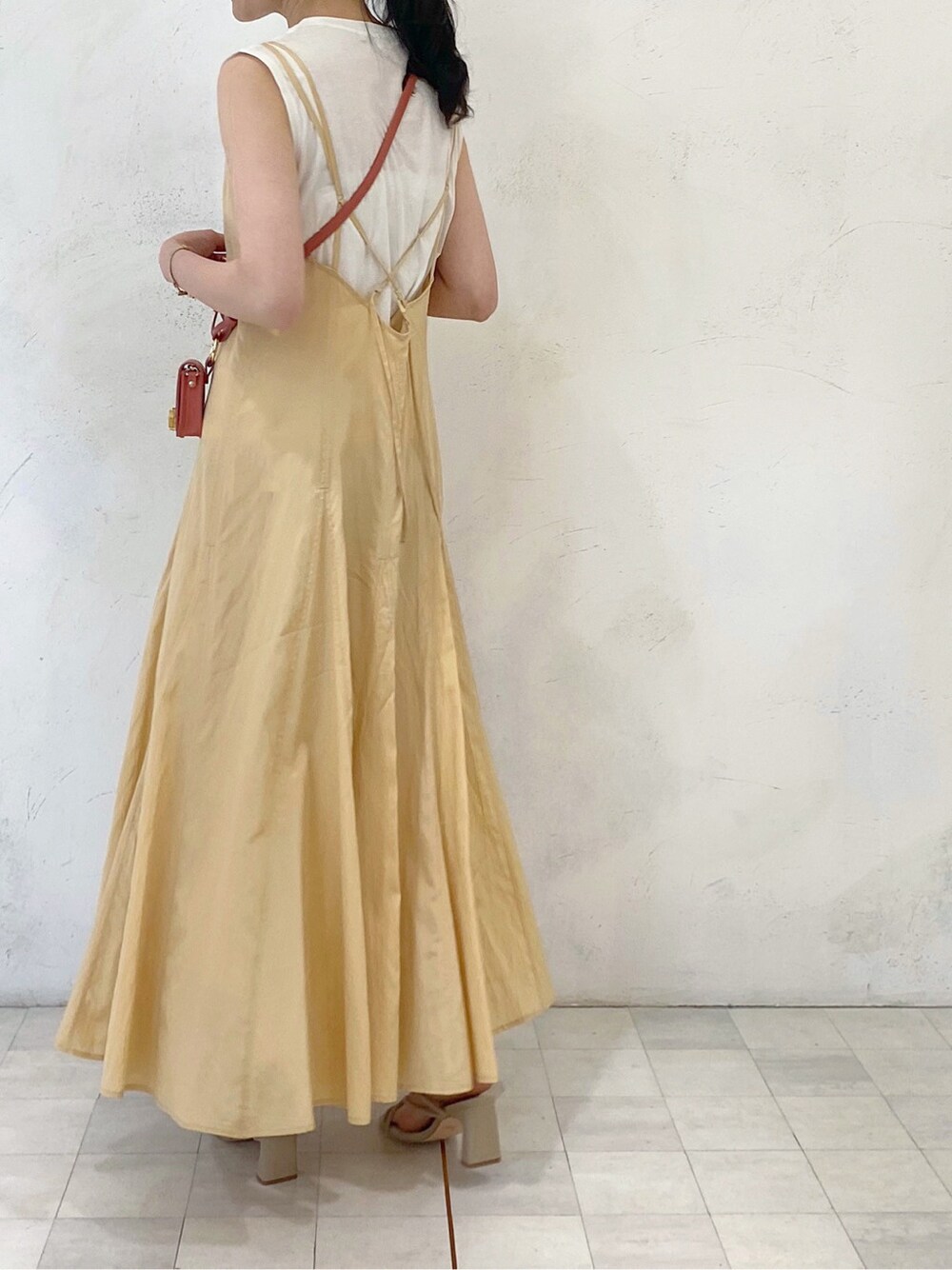 イエロー系のワンピース、ベージュ系のニット/セーター、ホワイト系のテーラードジャケットを着用したレディースの春コーディネートの7枚目の写真