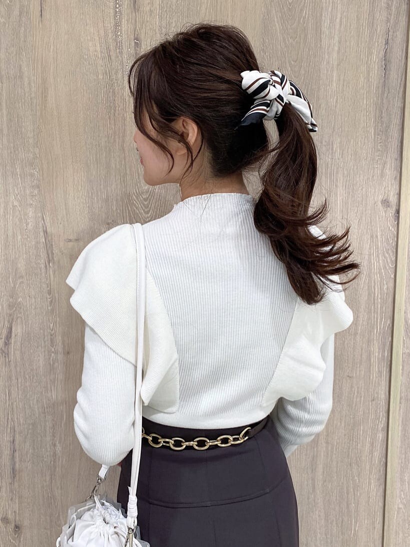 パープル系のスカート、ブラック系のその他シューズ、ホワイト系のニット/セーターを着用したレディースの冬コーディネートの6枚目の写真