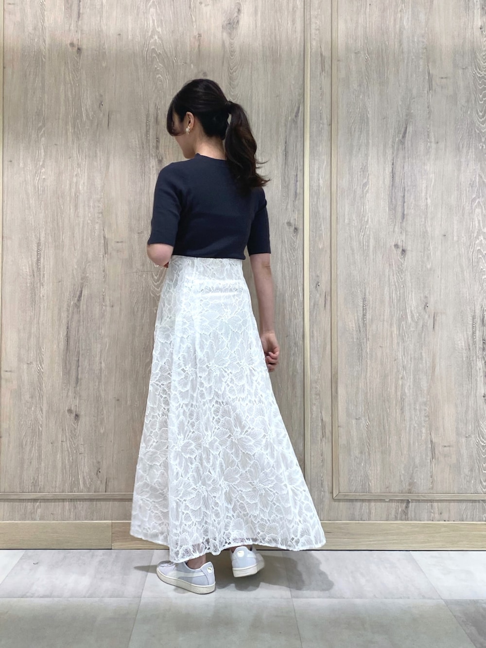 グレー系のスニーカー、ホワイト系のスカート、グレー系のニット/セーターを着用したレディースの冬コーディネートの4枚目の写真