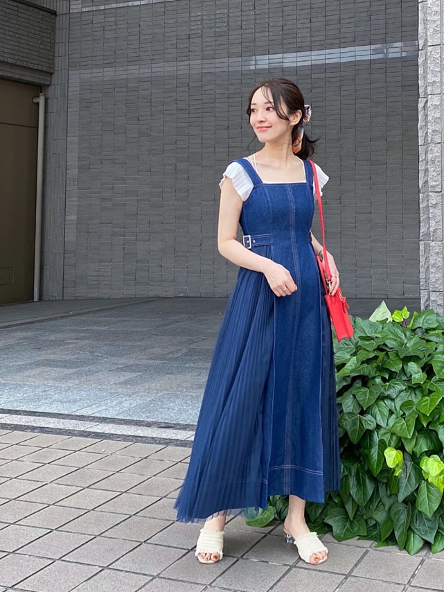 レッド系のハンドバッグ、ブルー系のワンピース、ホワイト系のニット/セーターを着用したレディースの夏コーディネートの3枚目の写真