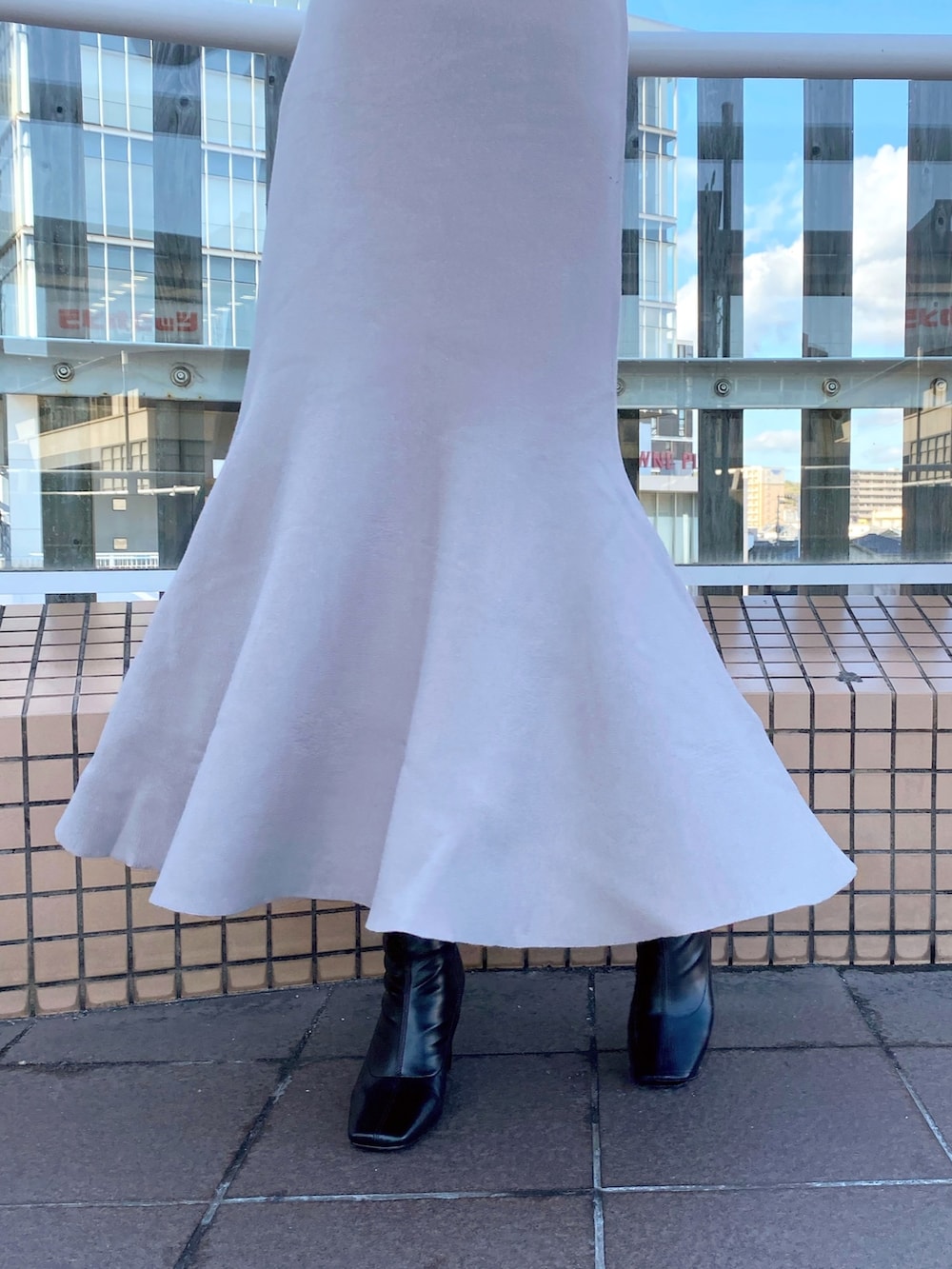 ブラック系のブーツ、ベージュ系のワンピース、ブラック系のダウンジャケット/コートを着用したレディースの冬コーディネートの9枚目の写真