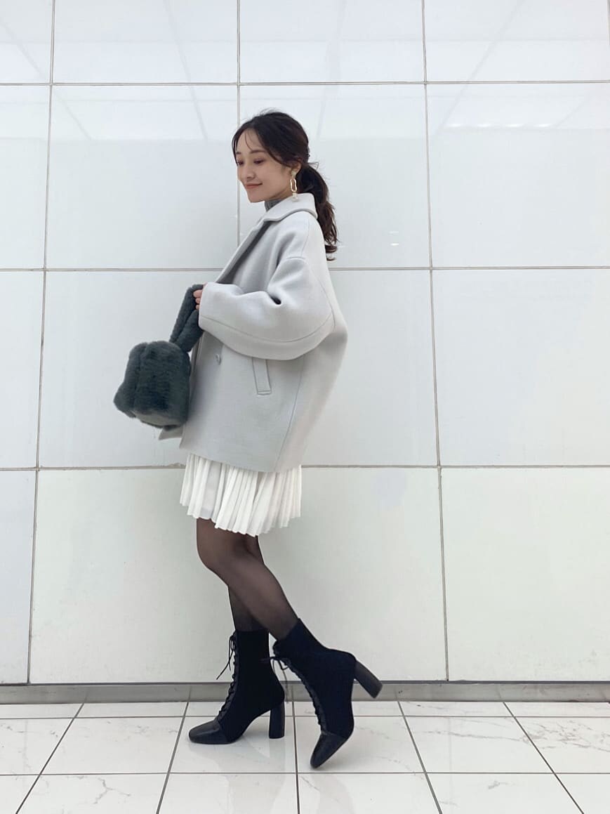 グリーン系のブルゾン、ブラック系のブーツ、グレー系のワンピースを着用したレディースの冬コーディネートの3枚目の写真