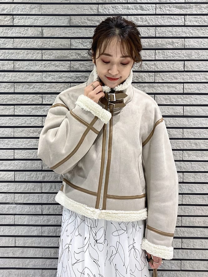 ベージュ系のハンドバッグ、ベージュ系のTシャツ/カットソー、ブルー系のワンピースを着用したレディースの秋コーディネートの3枚目の写真