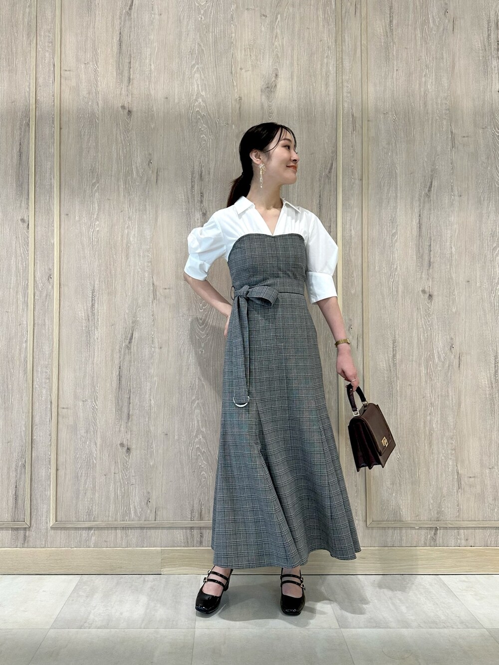 ブラウン系のパンプス、レッド系のハンドバッグ、その他のワンピースを着用したレディースの夏コーディネートの2枚目の写真