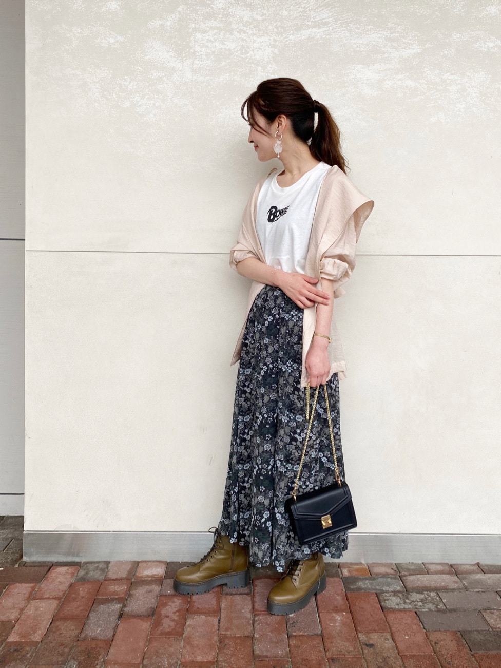 ブラック系のショルダーバッグ、ベージュ系のテーラードジャケット、ブラック系のスカートを着用したレディースの夏コーディネートの2枚目の写真