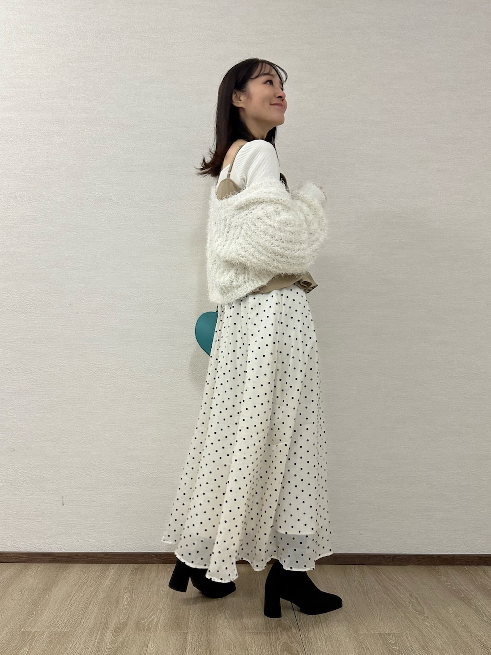 ホワイト系のカーディガン/ボレロ、ベージュ系のワンピース、ホワイト系のニット/セーターを着用したレディースの秋コーディネートの2枚目の写真