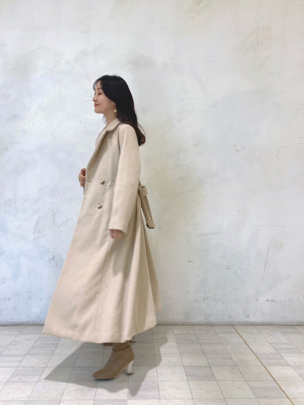 ホワイト系のワンピース、ベージュ系のブーツ、ベージュ系のチェスターコートを着用したレディースの冬コーディネートの3枚目の写真
