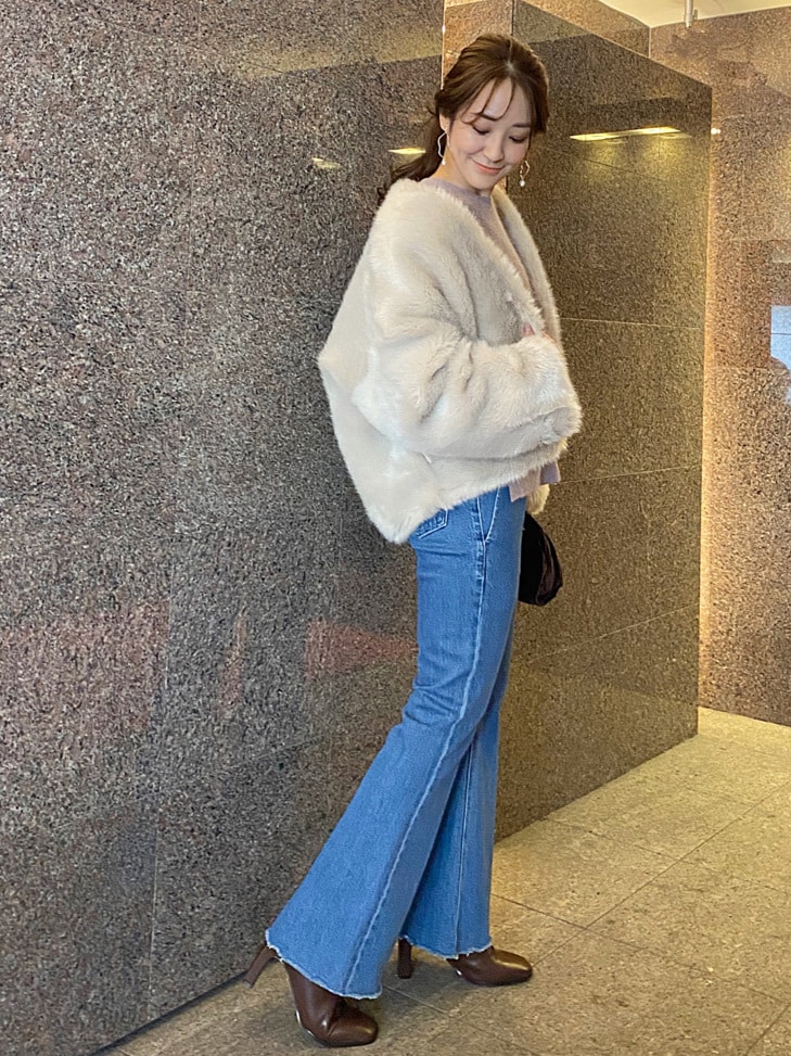 ベージュ系のその他アウター、ブラウン系のクラッチバッグ、ブルー系のその他パンツを着用したレディースの秋コーディネートの2枚目の写真