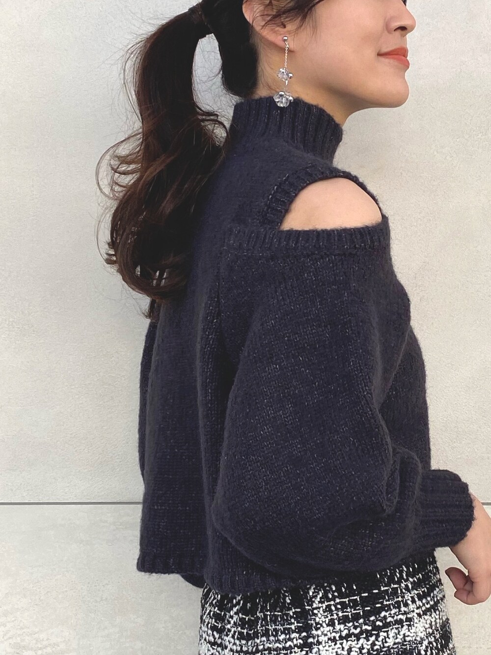 グレー系のニット/セーター、ブラック系のスカート、ブラック系のブーツを着用したレディースの秋コーディネートの5枚目の写真