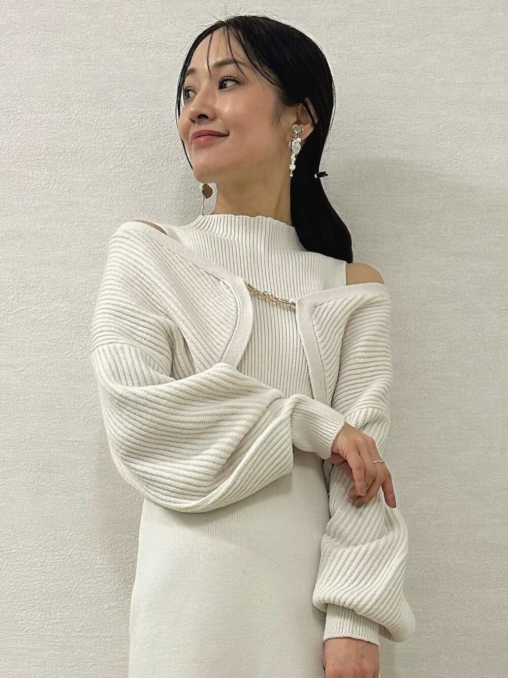 ホワイト系のワンピース、シルバー系のハンドバッグ、ブラック系のブーツを着用したレディースの秋コーディネートの5枚目の写真