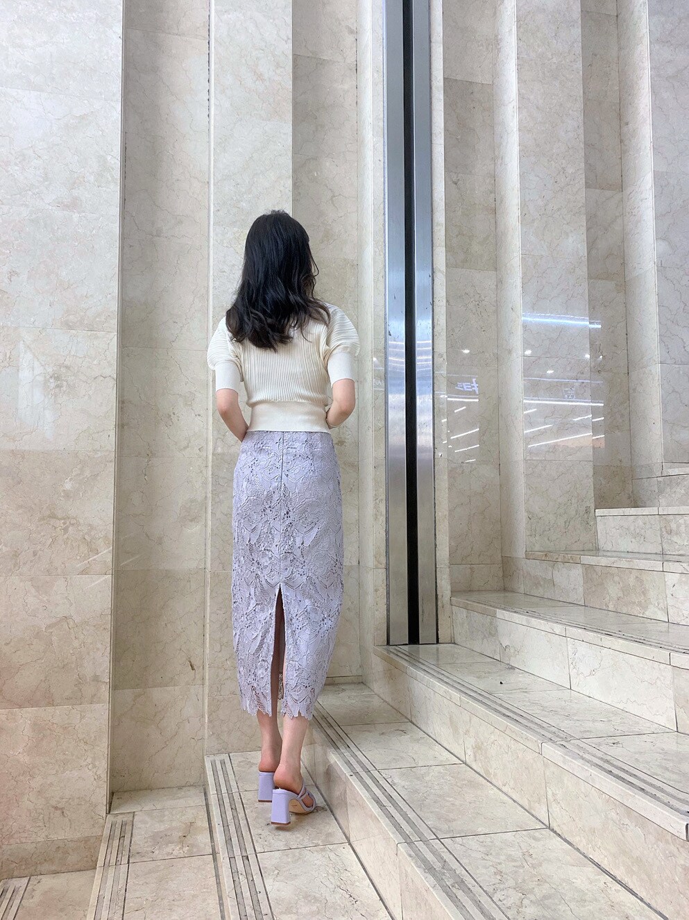 ホワイト系のハンドバッグ、パープル系のサンダル、パープル系のスカートを着用したレディースの春コーディネートの6枚目の写真