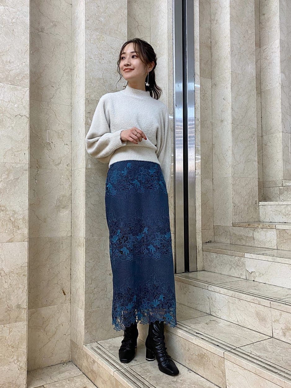 グリーン系のチェスターコート、ブルー系のスカート、ブラック系のその他シューズを着用したレディースの秋コーディネートの5枚目の写真