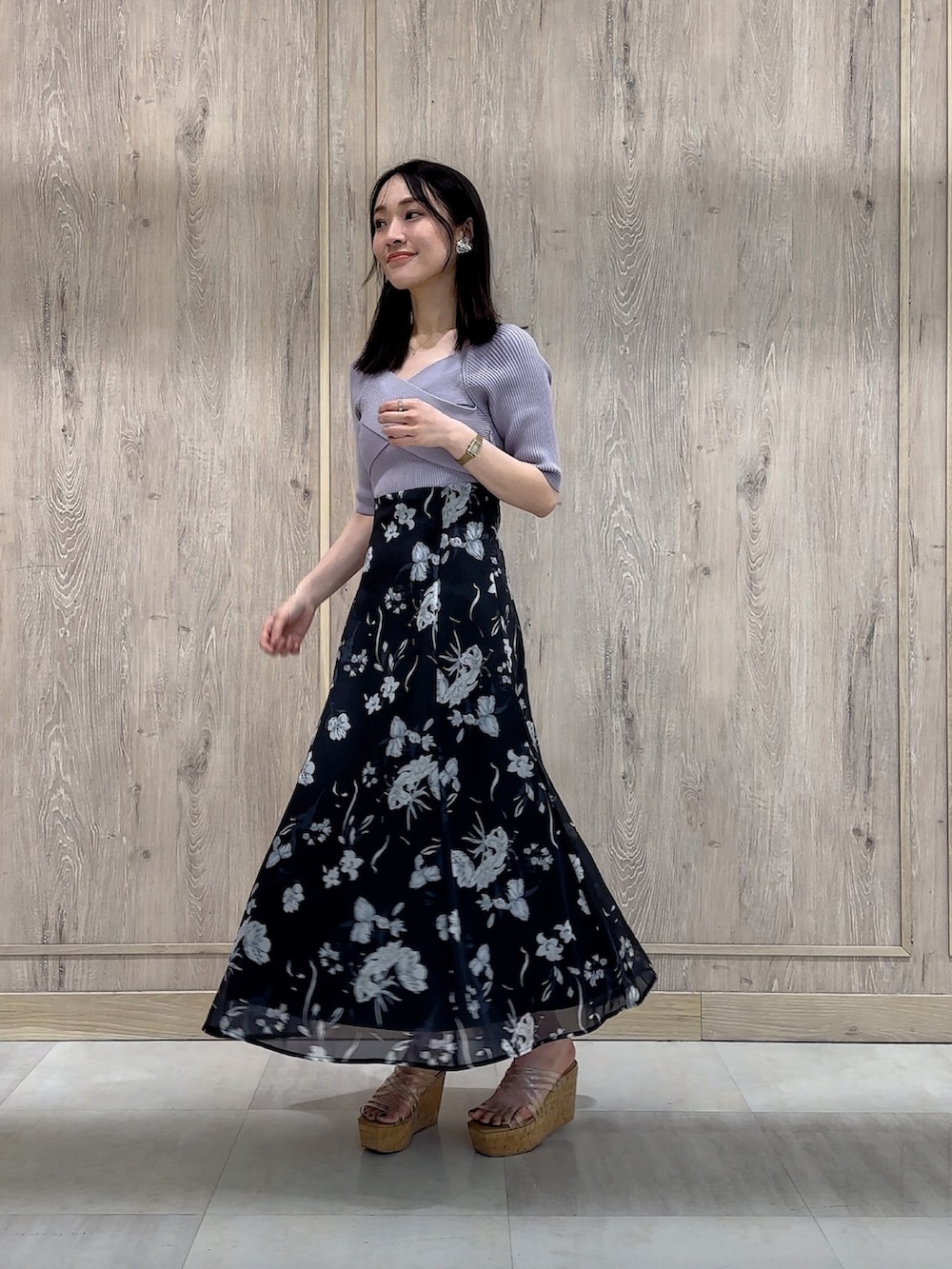 パープル系のワンピース、その他のサンダル、ゴールド系のイヤリングを着用したレディースの春コーディネートの2枚目の写真