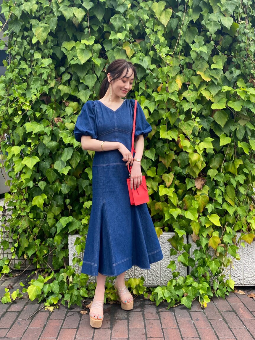 その他のサンダル、ブルー系のワンピース、レッド系のハンドバッグを着用したレディースの夏コーディネートの2枚目の写真