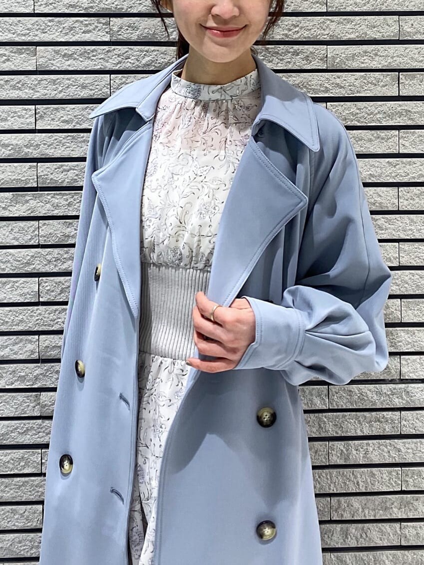 ブルー系のトレンチコート、ホワイト系のワンピース、ホワイト系のその他シューズを着用したレディースの冬コーディネートの4枚目の写真