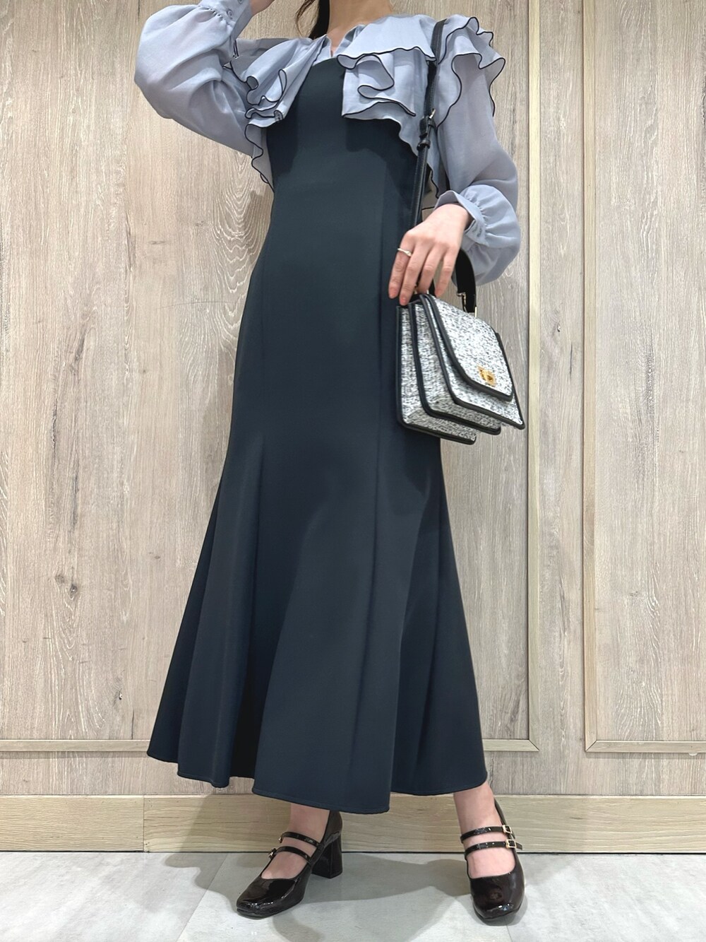 ブラック系のショルダーバッグ、グレー系のワンピース、ブラウン系のパンプスを着用したレディースの冬コーディネートの8枚目の写真