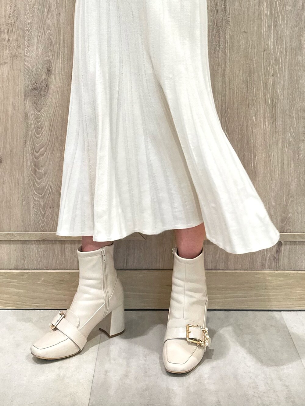 ホワイト系のブーツ、ホワイト系のワンピース、ゴールド系のイヤリングを着用したレディースの春コーディネートの8枚目の写真