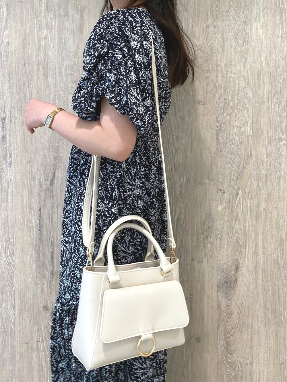 ホワイト系のローファー、ブラック系のワンピース、ホワイト系のハンドバッグを着用したレディースの冬コーディネートの6枚目の写真