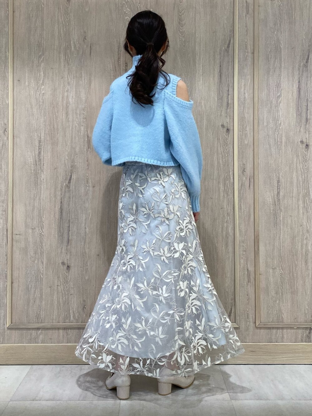 ブルー系のニット/セーター、ブルー系のスカート、ホワイト系のローファーを着用したレディースの秋コーディネートの3枚目の写真